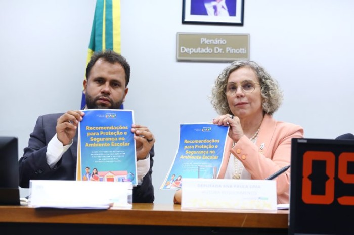Pastor Henrique Vieira e Ana Paula Lima seguram material sobre segurança nas escolas - (Foto: Vinicius Loures/Câmara dos Deputados)