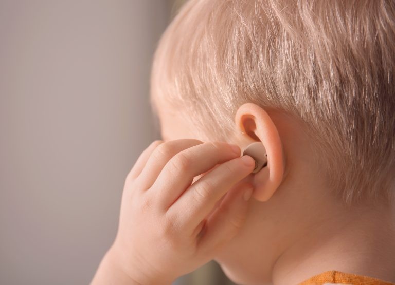 Criança usa parelho auditivo - (Foto: Olga Yastremska/Depositphotos)