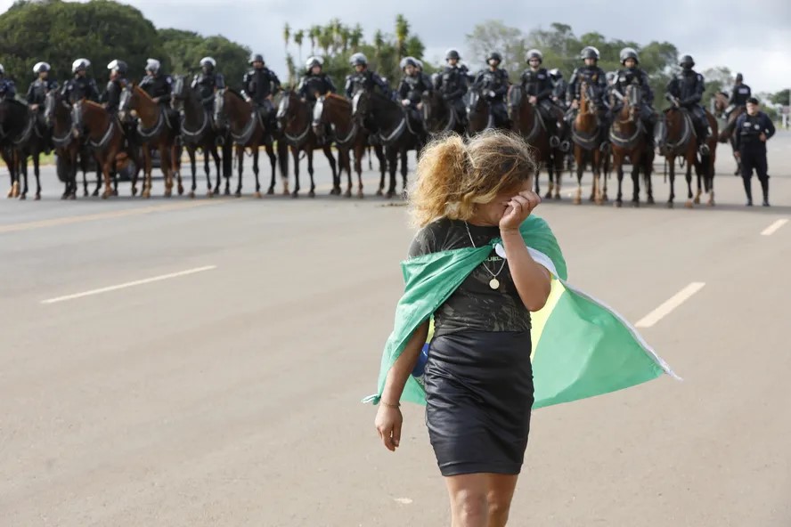 Manifestante bolsonarista chora enquanto policiais bloqueiam área do acampamento — Foto: Cristiano Mariz