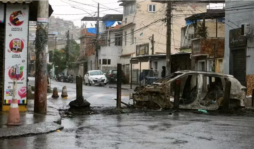 Acesso à Vila Cruzeiro, na semana passada, com carro queimado usado como barricada — Foto: Fabiano Rocha / Agência O Globo / 31-10-2025