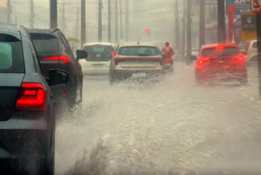 Sob chuva forte, veículos enfrentam avenida alagada em João Pessoa